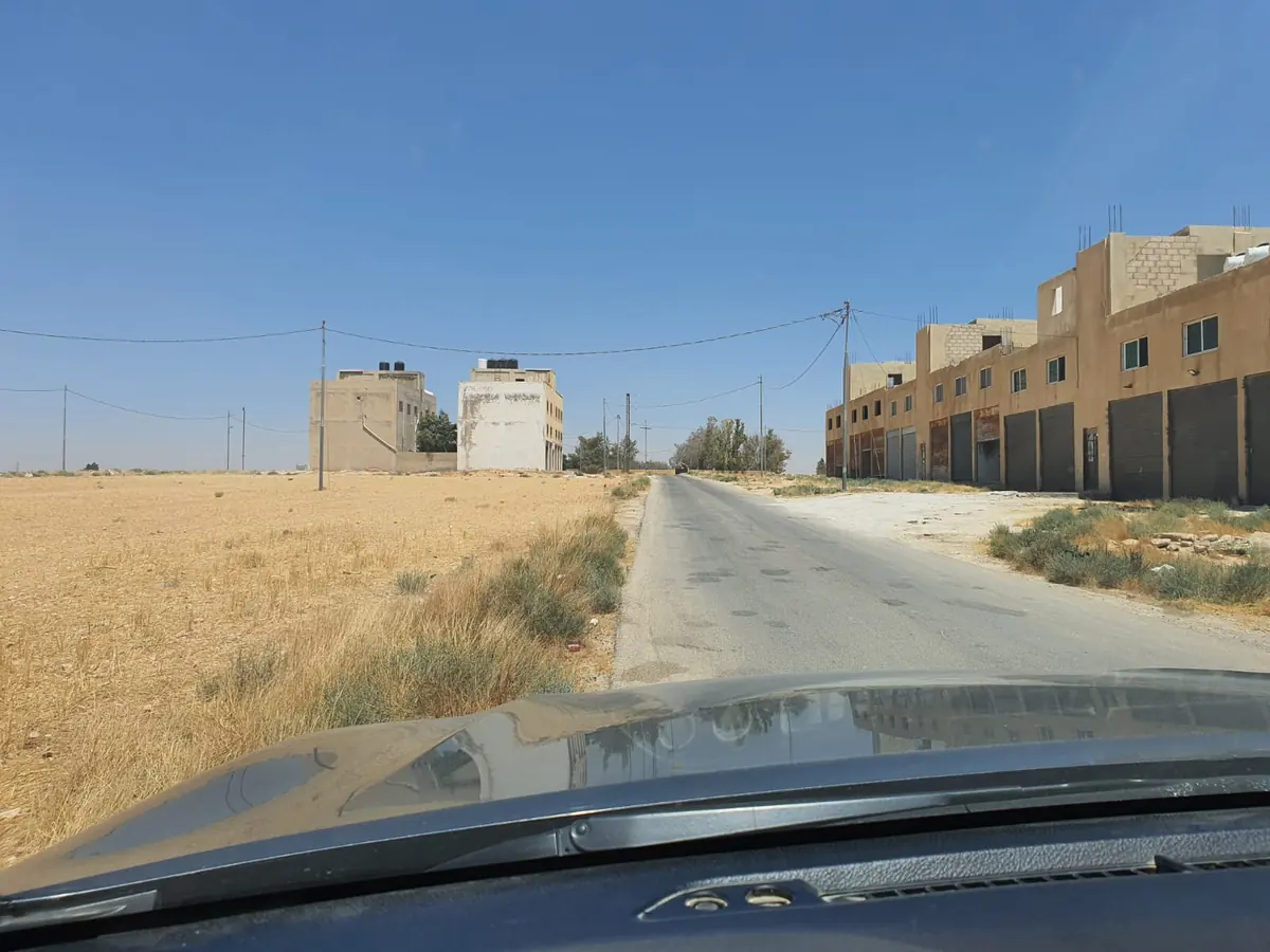 شارع معبّد في الجيزة تصطف عليه مستودعات ومحال بأبواب حديدية