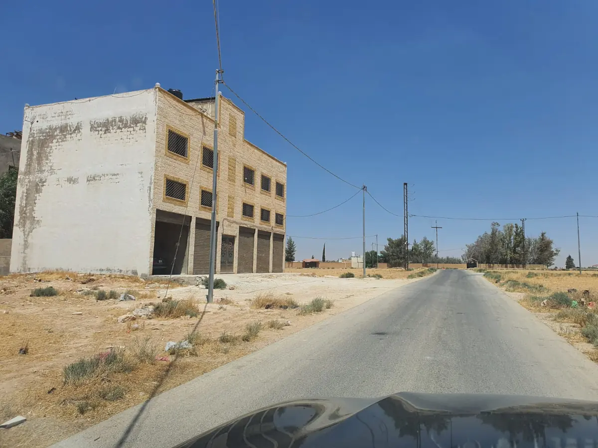 مبنى من طابقين بواجهة حجرية وأبواب ورش في منطقة الجيزة